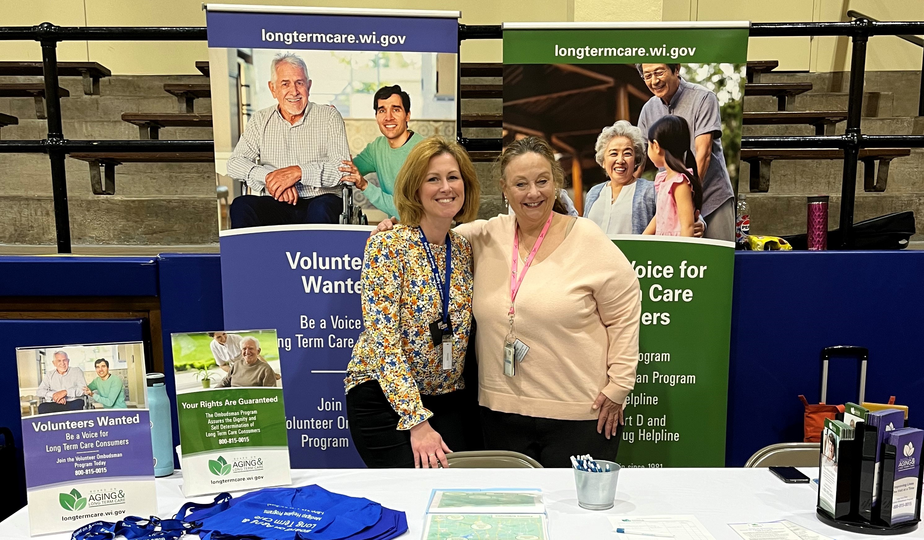Photo of two staff at an outreach event booth